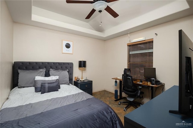 bedroom with ceiling fan and a raised ceiling