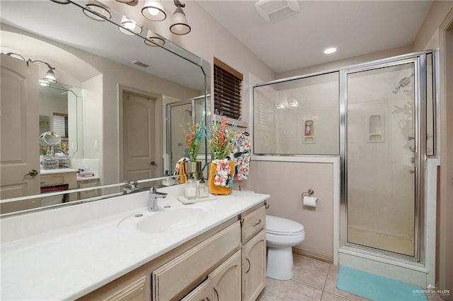 bathroom featuring tile patterned floors, vanity, toilet, and walk in shower