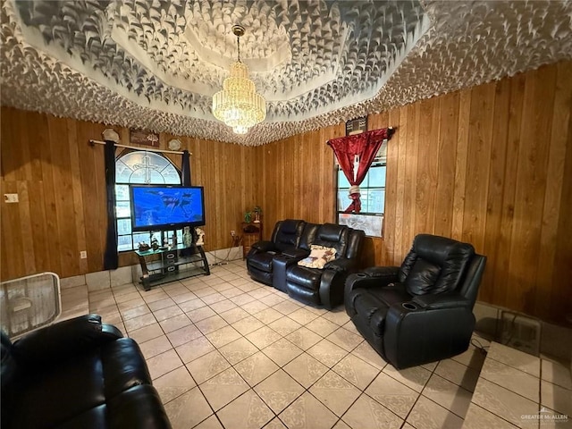 living room with tile patterned floors, wood walls, and an inviting chandelier