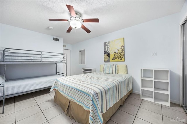 6300 Padre Blvd Unit 871, South Padre Island, TX 78597 - bedroom featuring light tile patterned floors, ceiling fan, and a textured ceiling