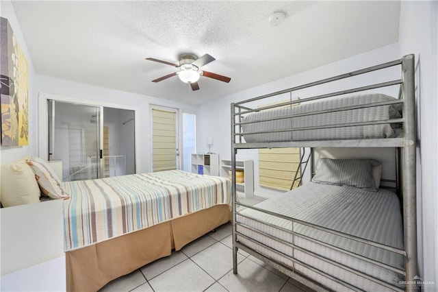 6300 Padre Blvd Unit 871, South Padre Island, TX 78597 - bedroom with tile patterned flooring, a textured ceiling, and a ceiling fan