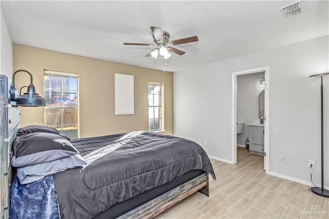 bedroom featuring ceiling fan, ensuite bath, and light wood-type flooring