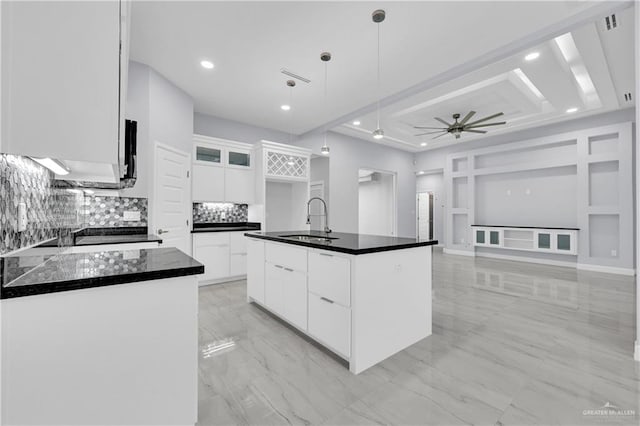 kitchen with a center island with sink, white cabinets, sink, ceiling fan, and decorative light fixtures