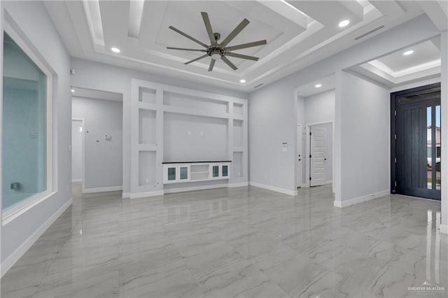 unfurnished living room featuring ceiling fan, built in shelves, and a tray ceiling