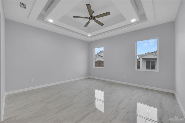 spare room featuring ceiling fan, a wealth of natural light, and a tray ceiling