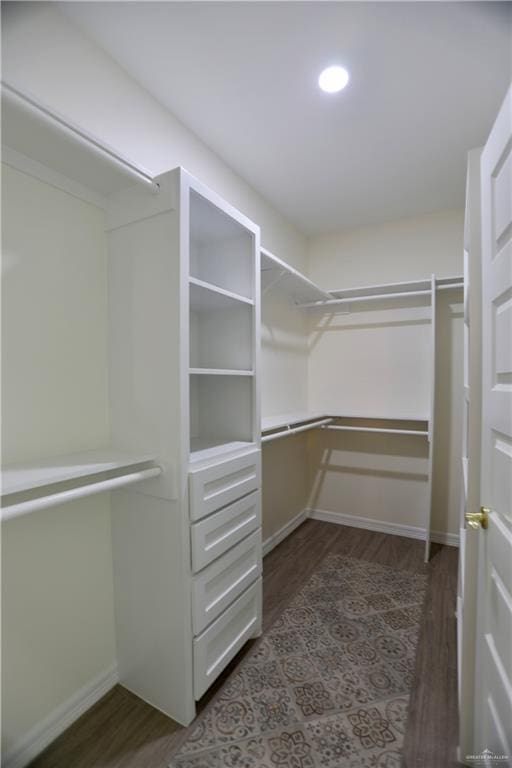 spacious closet with dark wood-type flooring