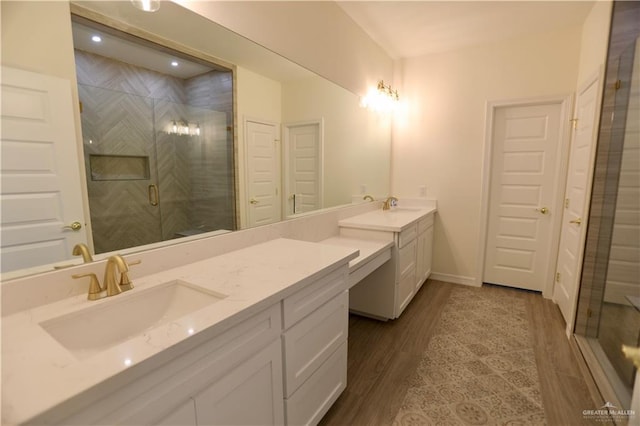 bathroom featuring hardwood / wood-style flooring, vanity, and walk in shower