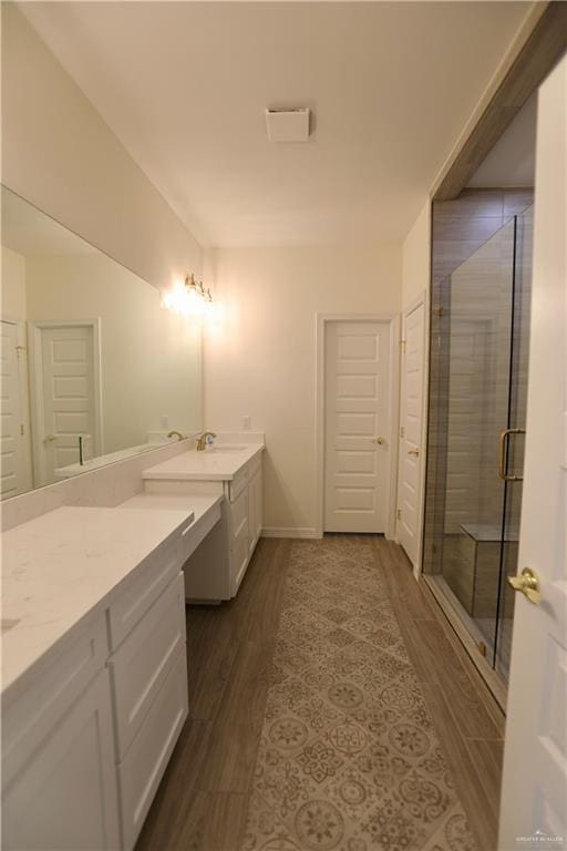 bathroom with a shower with door, vanity, and hardwood / wood-style flooring