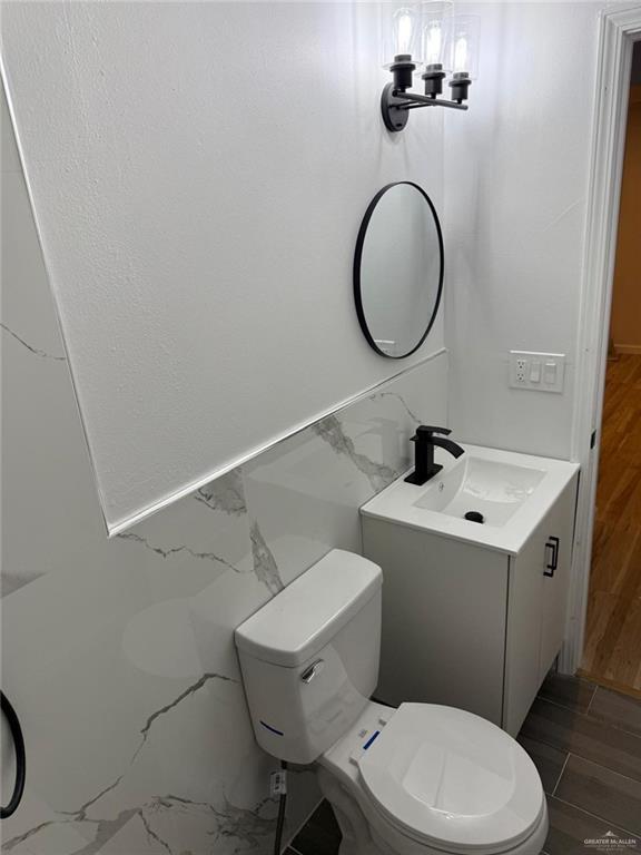 bathroom featuring vanity, toilet, and wood finished floors