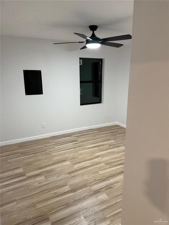 unfurnished room featuring baseboards, light wood-style flooring, and a ceiling fan