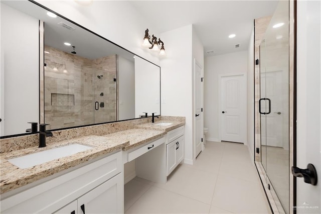 bathroom featuring an enclosed shower, vanity, toilet, and tile patterned floors