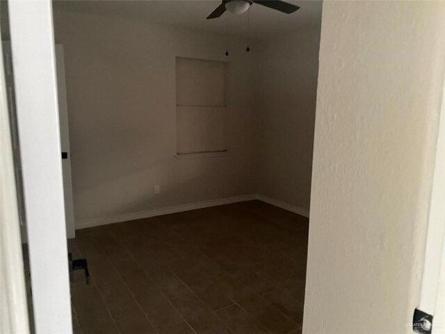 empty room featuring ceiling fan and dark wood-type flooring