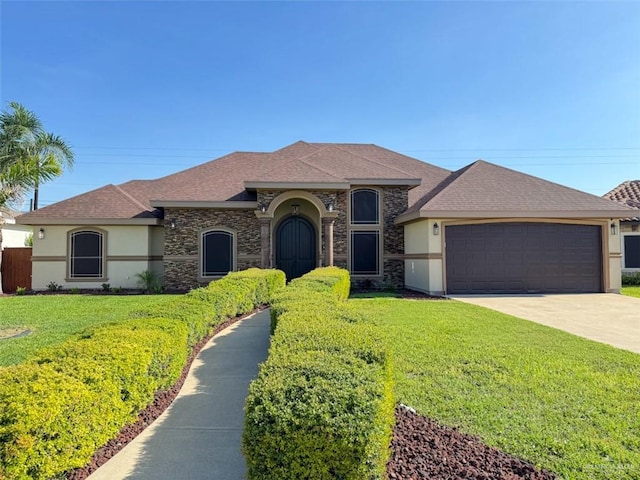 view of front of home featuring stucco siding, stone siding, a front yard, a garage, and driveway
