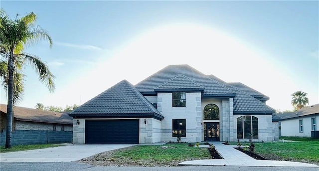 915 Durango St, Mission, TX 78572 - french provincial home featuring a garage, central AC unit, concrete driveway, and a tile roof
