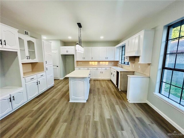 915 Durango St, Mission, TX 78572 - kitchen featuring light wood finished floors, white cabinetry, glass insert cabinets, and a kitchen island