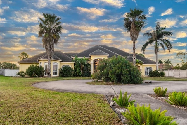 single story home with a lawn