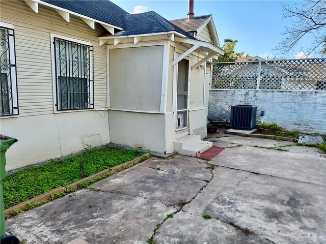 view of side of property with central air condition unit and a patio area