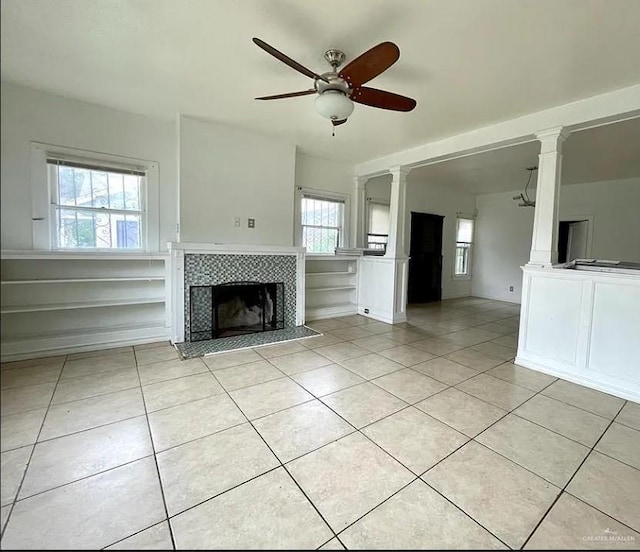 unfurnished living room featuring a tile fireplace, ceiling fan, and light tile patterned flooring