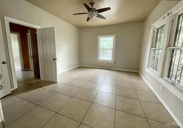 empty room featuring ceiling fan and light tile patterned floors