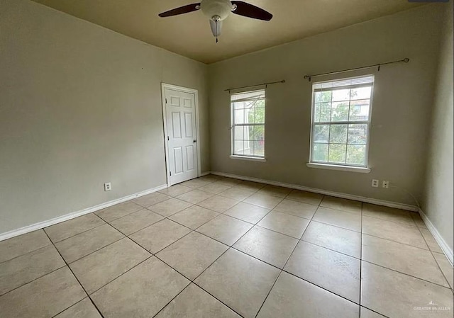 tiled empty room featuring ceiling fan