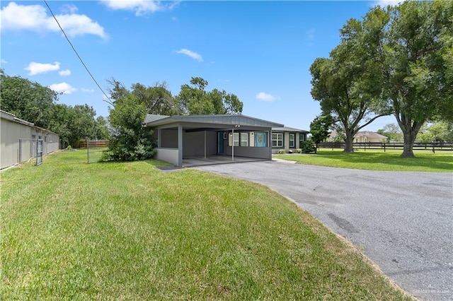 23807 Stuart Place Rd, Harlingen, TX 78552 - rear view of house featuring asphalt driveway and a carport