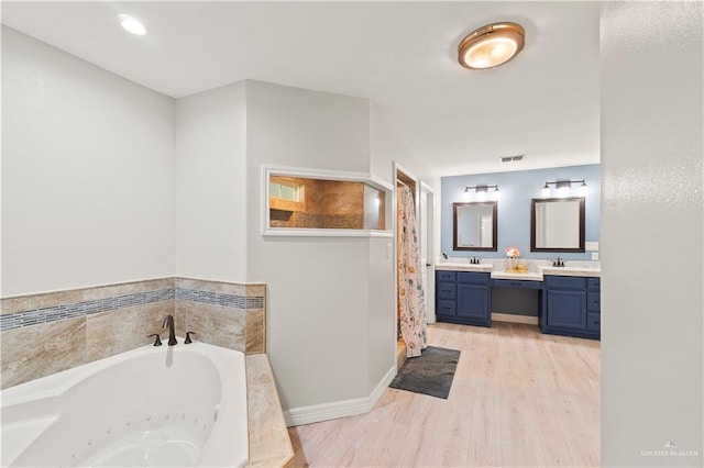 23807 Stuart Place Rd, Harlingen, TX 78552 - bathroom featuring double vanity, a whirlpool tub, wood finished floors, and a shower