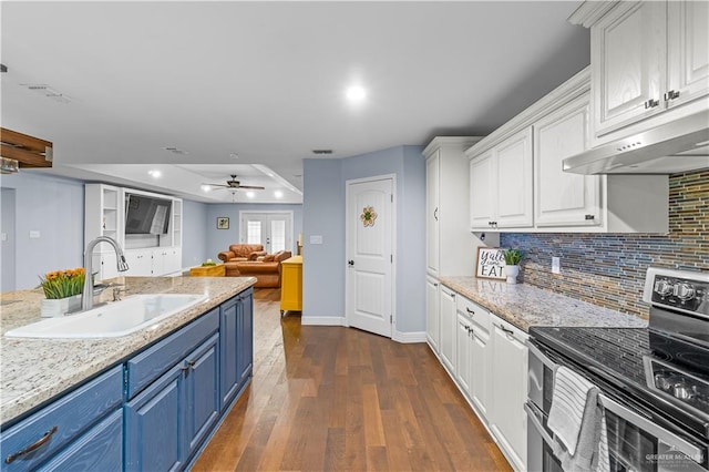 23807 Stuart Place Rd, Harlingen, TX 78552 - kitchen with stainless steel electric range oven, blue cabinetry, white cabinetry, dark wood-type flooring, and tasteful backsplash