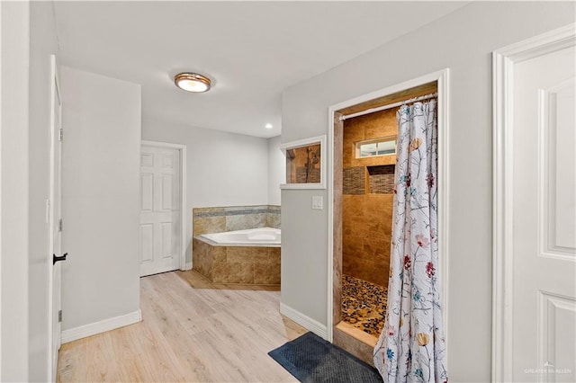 23807 Stuart Place Rd, Harlingen, TX 78552 - bathroom featuring a bath, wood finished floors, a tile shower, and recessed lighting