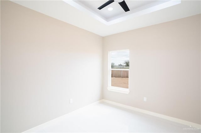 empty room featuring baseboards, a raised ceiling, a ceiling fan, and recessed lighting