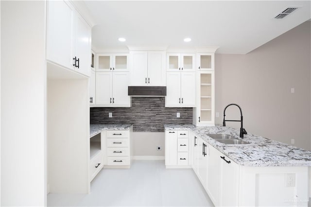 kitchen with white cabinetry, glass insert cabinets, and a sink