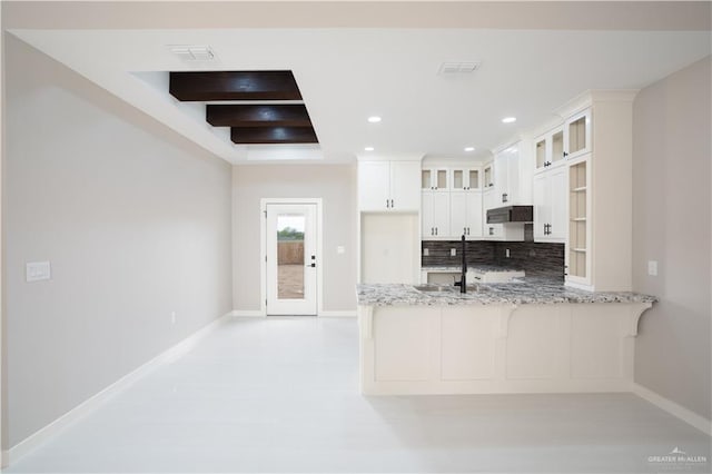 kitchen featuring visible vents, glass insert cabinets, light stone counters, a peninsula, and white cabinetry