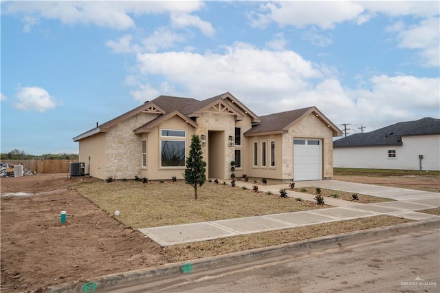 view of front of property with cooling unit, a garage, fence, stone siding, and concrete driveway