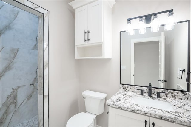 bathroom with toilet, vanity, and a marble finish shower