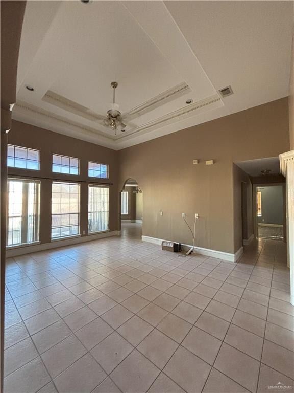 tiled spare room with a tray ceiling