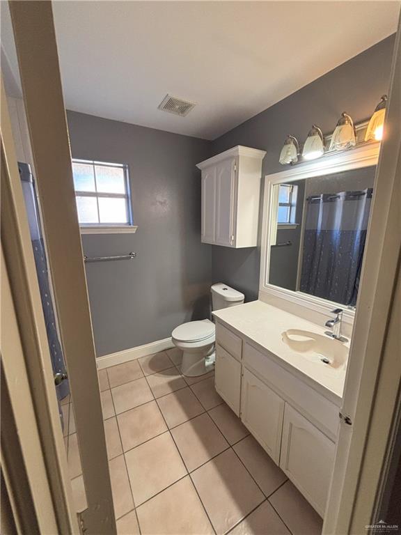 bathroom featuring toilet, vanity, and tile patterned floors