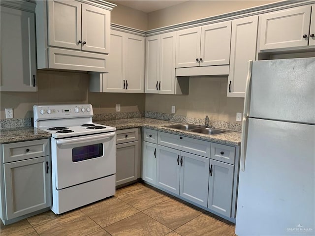 kitchen with gray cabinets, white appliances, a sink, and under cabinet range hood