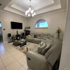 4907 N 25th Ln, Mcallen, TX 78504 - living room with a tray ceiling, tile patterned flooring, ornamental molding, and an inviting chandelier