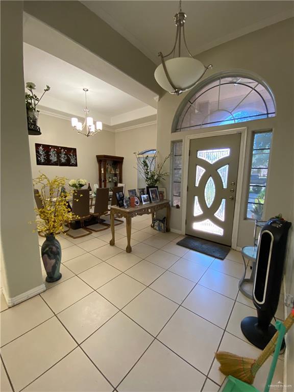 4907 N 25th Ln, Mcallen, TX 78504 - entryway featuring crown molding, a chandelier, and light tile patterned flooring