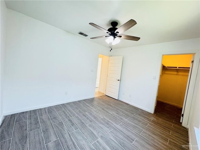 606 S Paseo Del Rey St, Mission, TX 78572 - unfurnished bedroom featuring wood finished floors, a spacious closet, baseboards, a closet, and ceiling fan