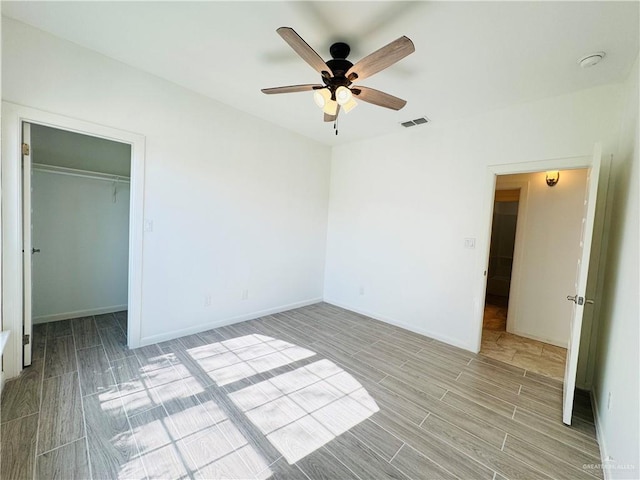606 S Paseo Del Rey St, Mission, TX 78572 - unfurnished bedroom with wood finished floors, baseboards, a spacious closet, ceiling fan, and a closet