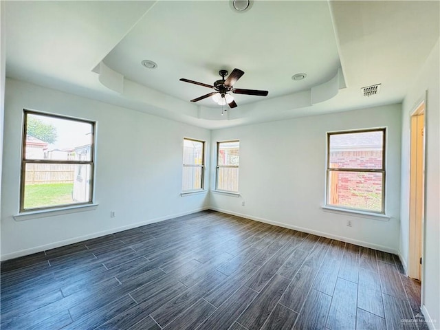 606 S Paseo Del Rey St, Mission, TX 78572 - unfurnished room with a tray ceiling, healthy amount of natural light, baseboards, and dark wood-style flooring