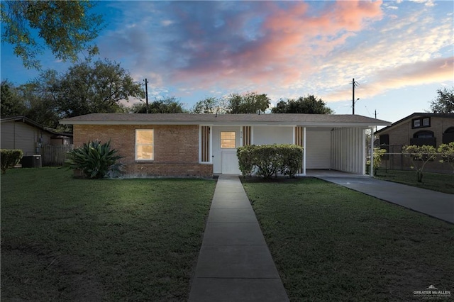 single story home featuring fence, a lawn, and brick siding