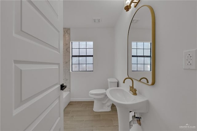 bathroom featuring shower / tub combination and toilet