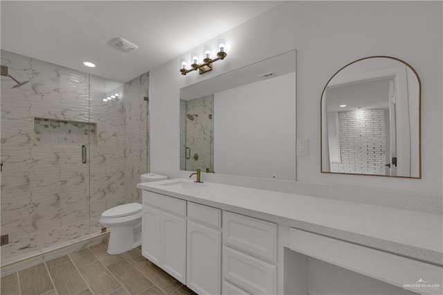 bathroom with vanity, toilet, and a shower with shower door