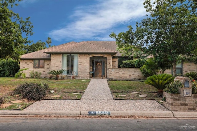 view of front of house featuring brick siding and a front lawn
