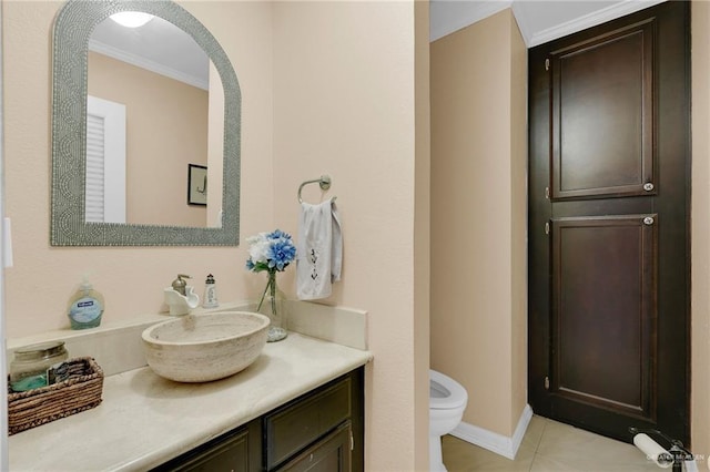 bathroom featuring ornamental molding, toilet, vanity, tile patterned flooring, and baseboards