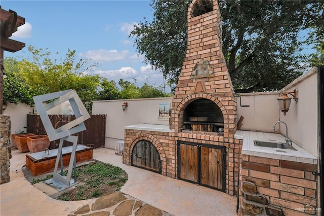 view of patio / terrace featuring a sink and fence