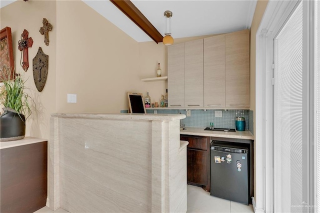 indoor wet bar featuring decorative backsplash, refrigerator, and decorative light fixtures