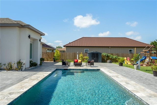 view of pool featuring a playground and a patio