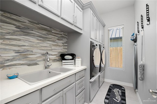 clothes washing area featuring cabinets, independent washer and dryer, light tile patterned floors, and sink